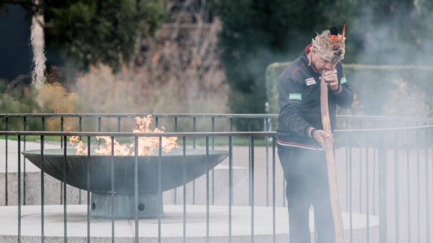 Eternal flame with smoke surrounding Uncle Ron Murray playing didgeridoo